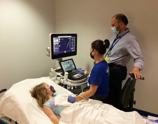 Doctor and tech perform echocardiogram on young patient